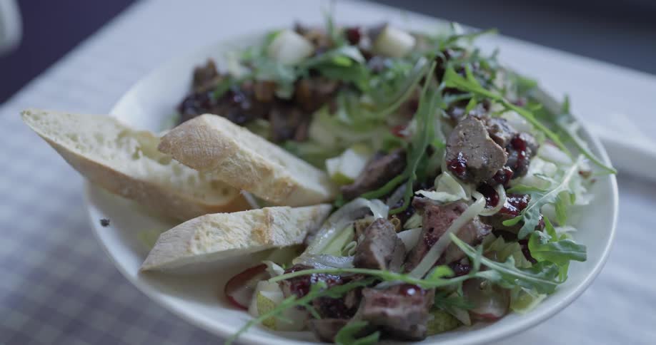 A plate of salad is put down on a table