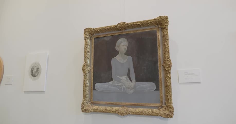 Painting of woman sitting on floor hangs on wall