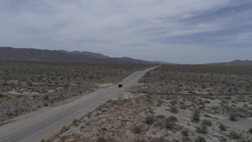 A vehicle driving on the road toward the mountains