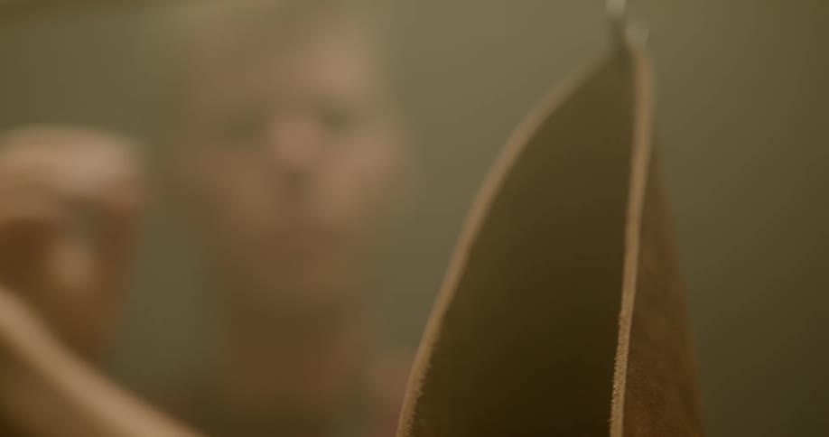 A man is looking at pieces of leather