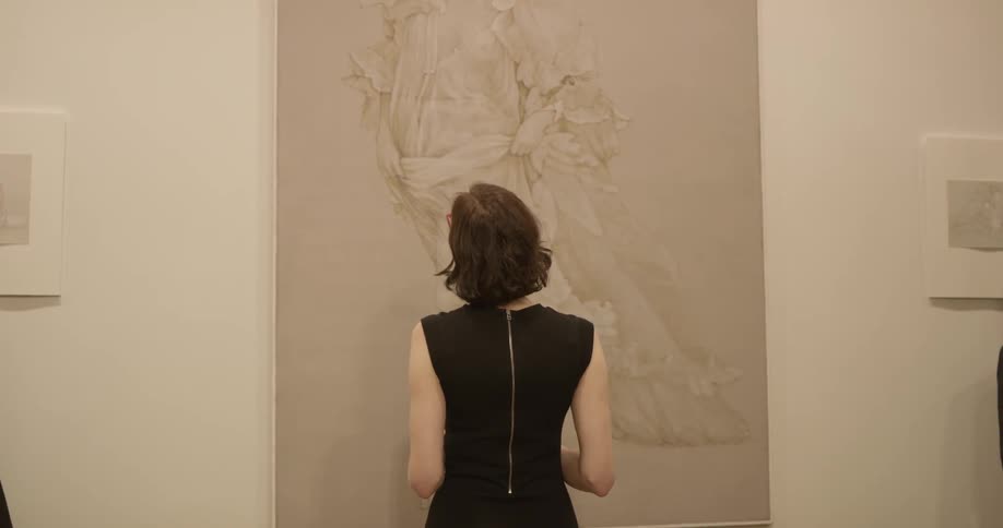 Woman stares at a painting on the wall