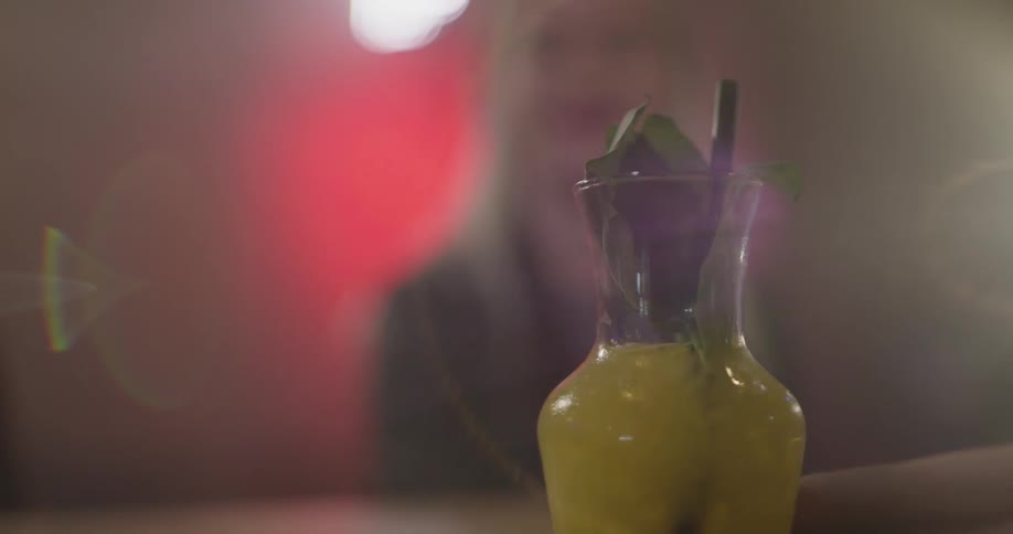 A woman grabbing a drink off a table
