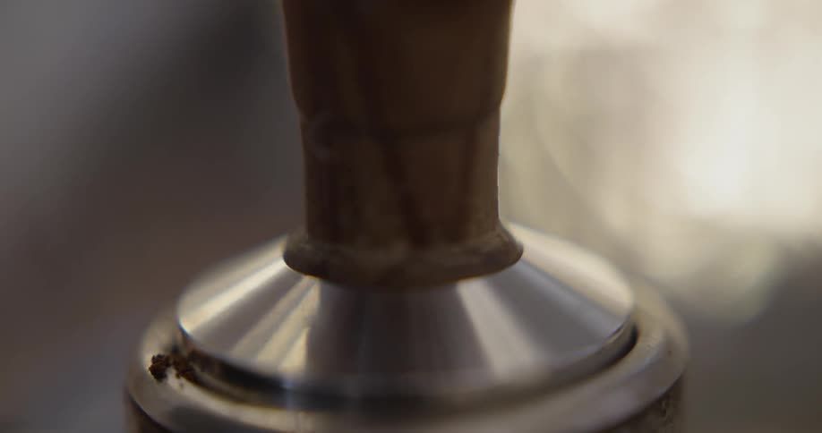 Person tamping coffee in an espresso machine