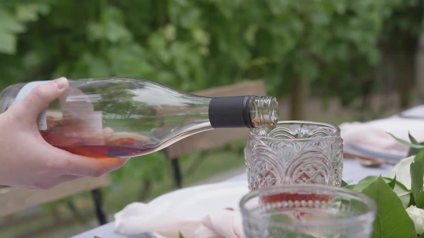 A person is pouring liquids into a cup