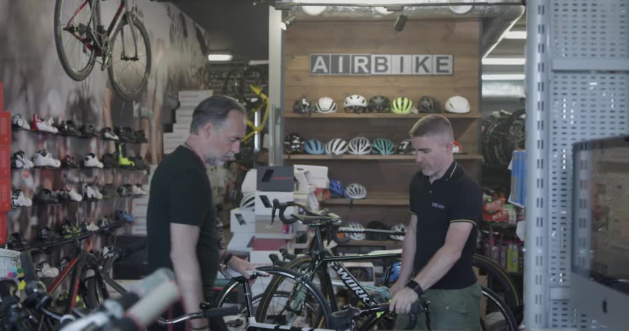A bicycle shop employee helps a customer