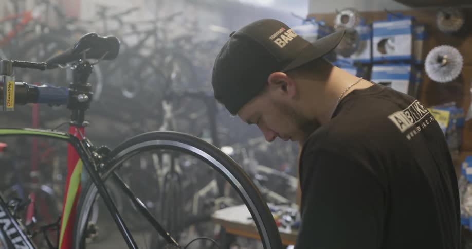 A man is spinning a tire on a bicycle