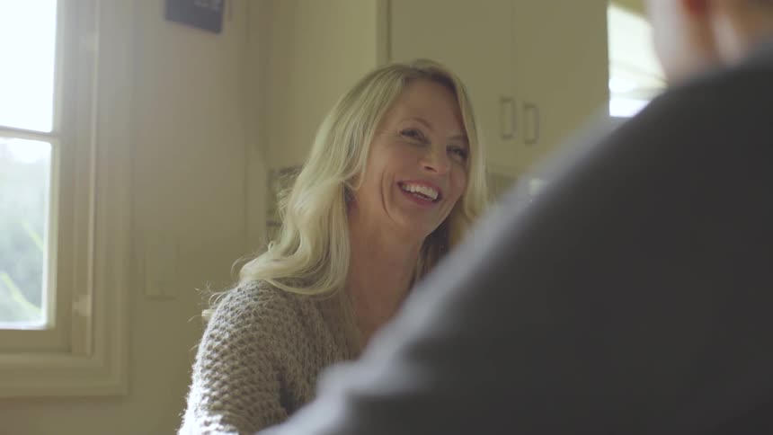 A woman laughing hysterically at an unknown person she's talking to