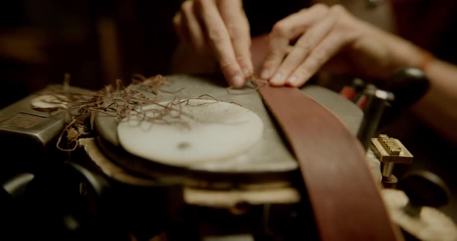 Person slices thin strip off of belt form