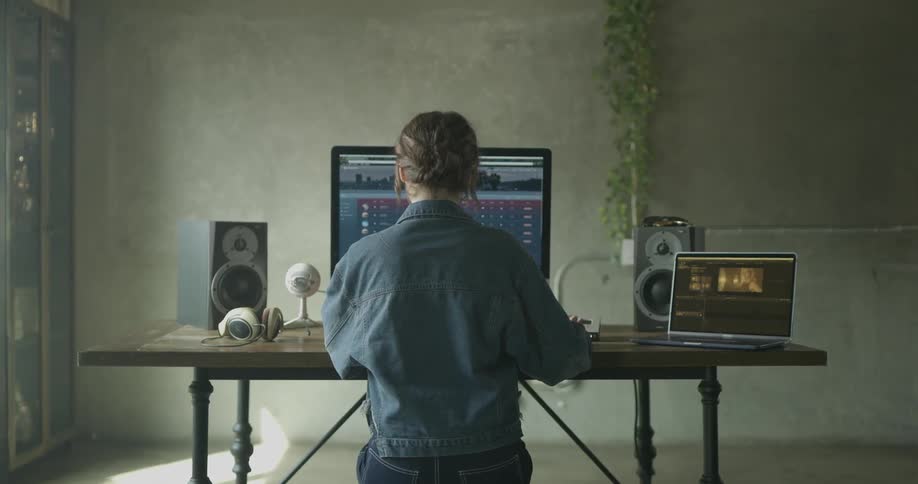 Woman sits at desk scrolling through results on a large monitor