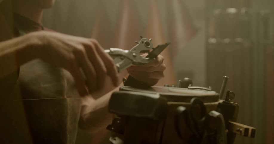 A man uses a hole punch tool