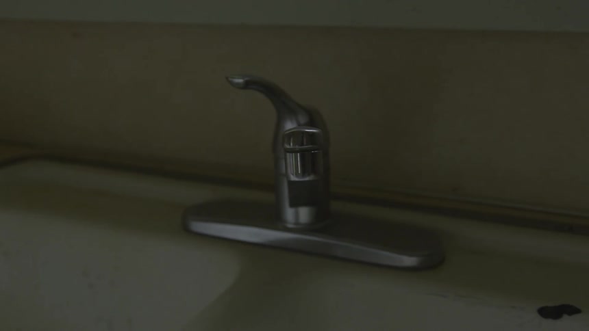 A faucet is shown in a dark room