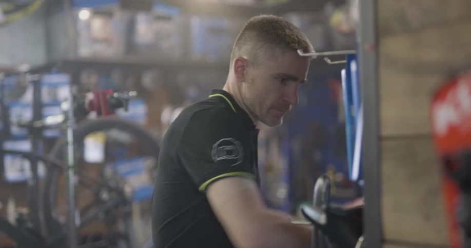 A bicycle shop employee works in the shop