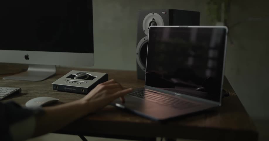 A person types and uses the track ad of a laptop computer while sitting at a desk