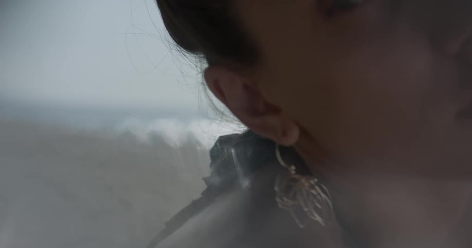 A woman is looking around by the beach