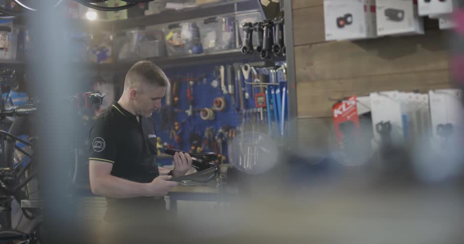 A bicycle shop employee works in the shop