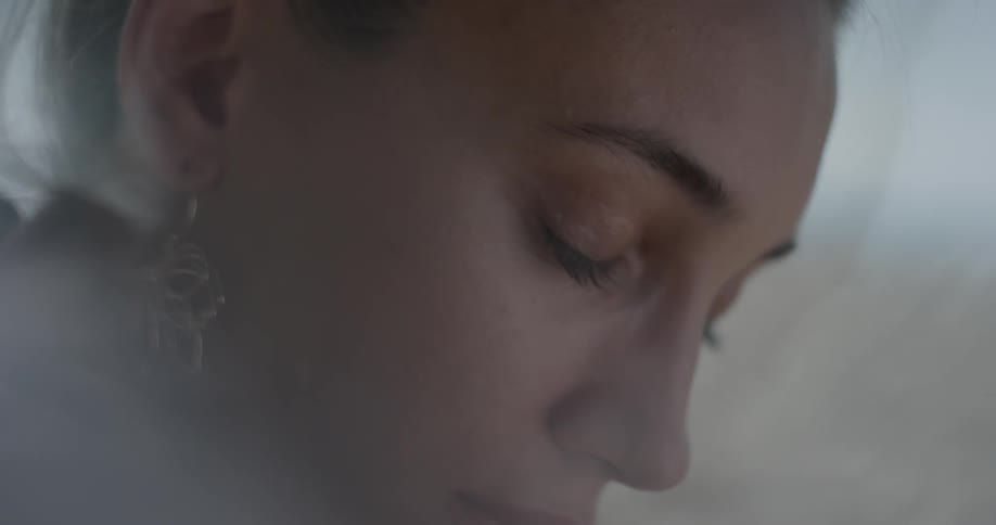 A woman is staring and closing her eyes indoors