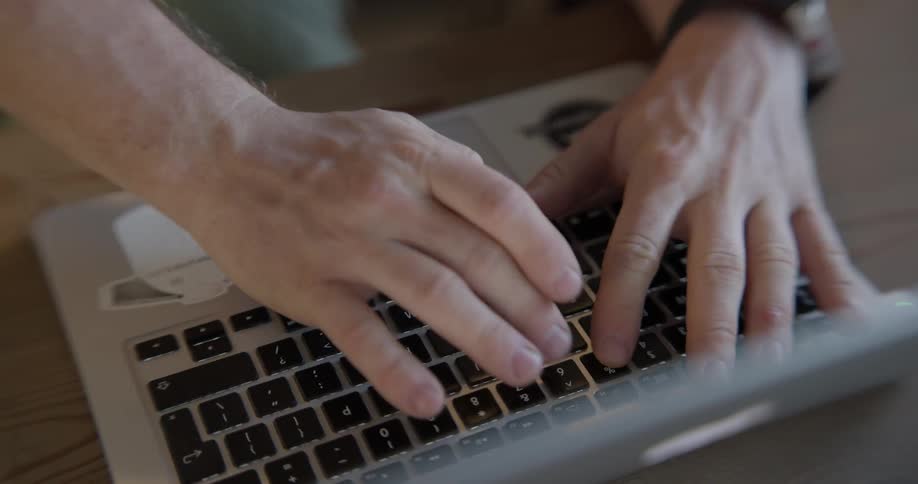 A man types on the laptop in front of him
