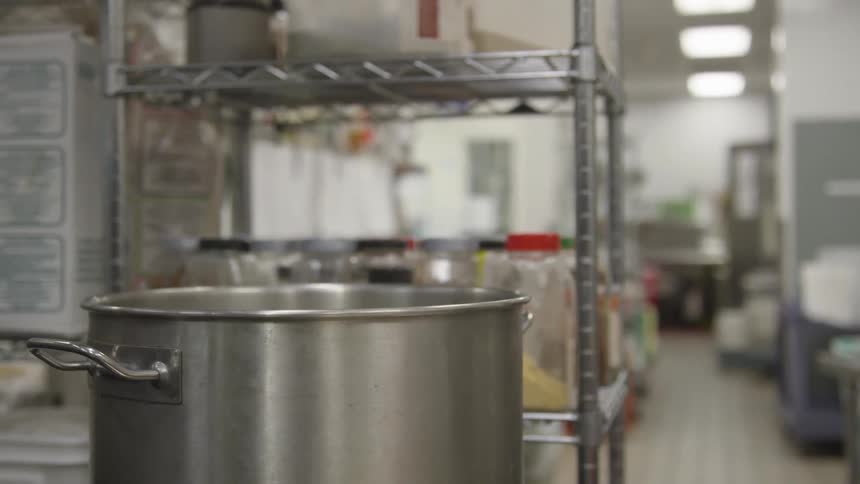 A pot that is boiling in a kitchen at a restaurant