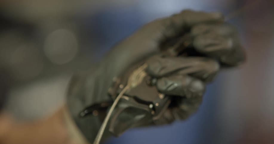 A person uses a tool to dig out a piece of wire