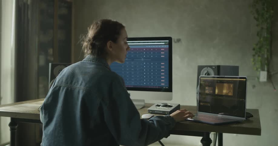 Female checks her laptop and desktop computers