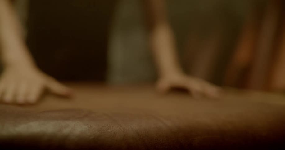Man grabs hanging leather and throws it over a table