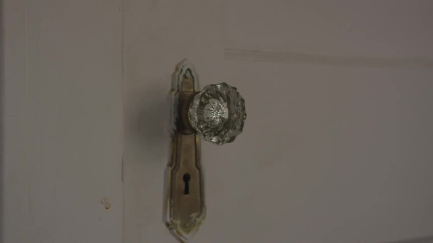 A clear glass door known in a white door slowly twisting