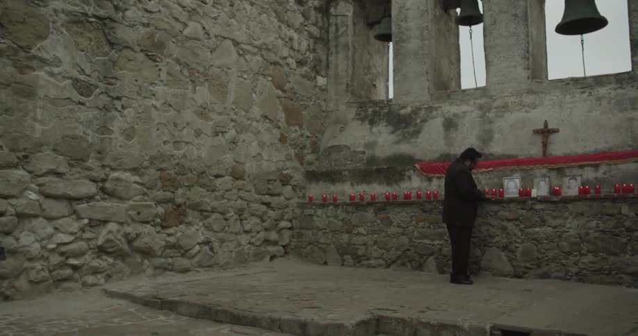 Person lights candles on a ledge outside of a church