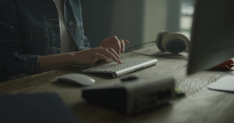 A woman typing on a wireless keyboard
