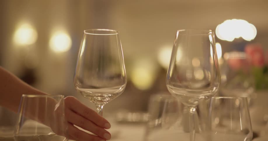 A person sets a glass on a table