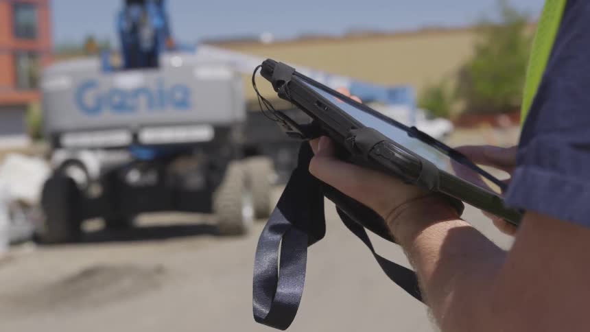 A person is holding a tablet outside