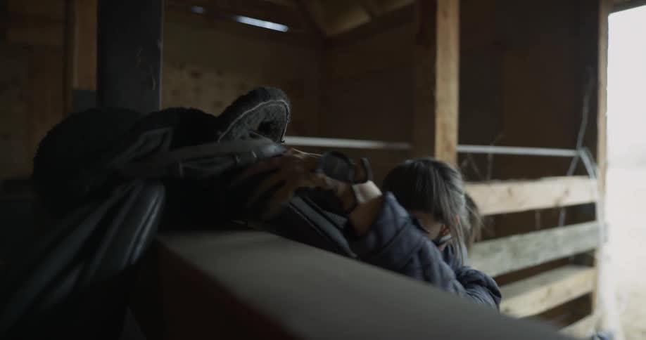 Woman putting a saddle on a shelf