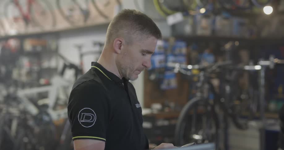A bicycle shop employee uses a phone