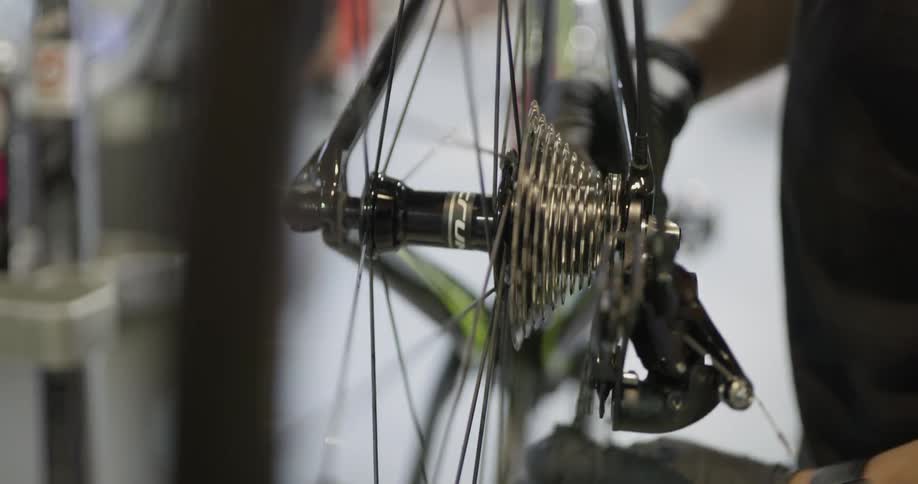 Man places chain on bicycle