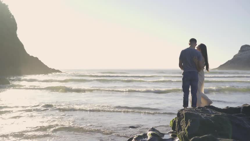 A man and woman stand on a rock together