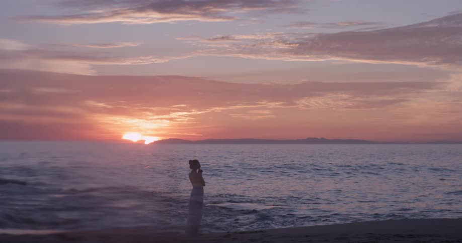 A woman stands in chest deep ocean waters
