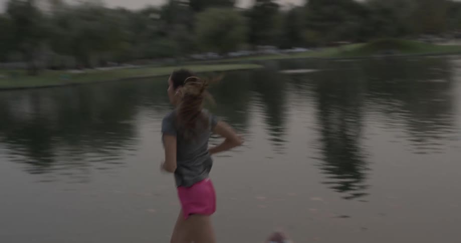 Woman runs past pond in park