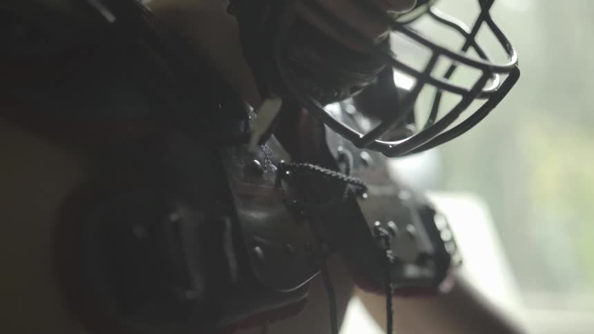 Football equipment is worn by a male outside in the sunny weather
