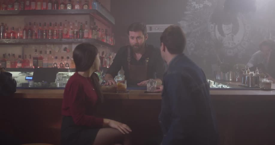 Bartender comes to check if two patrons need anything