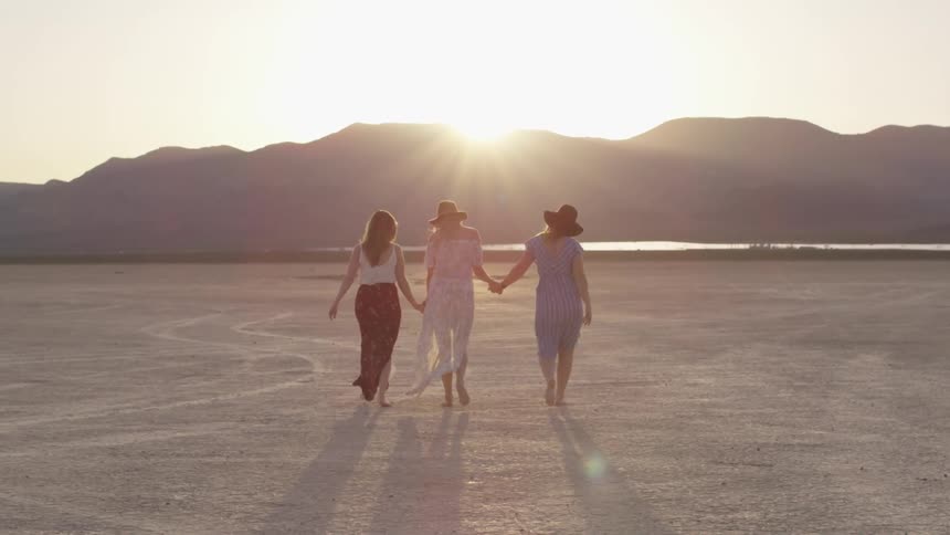 Three women walking around in a dry lake bed