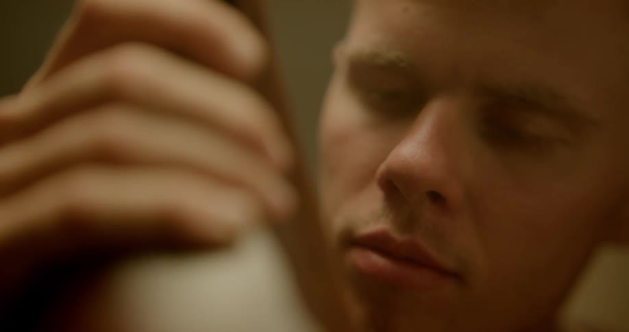 A man leans in to smell a piece of leather
