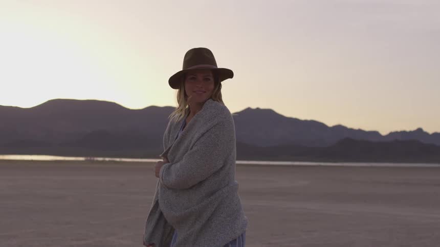 A woman wraps a sweater around herself