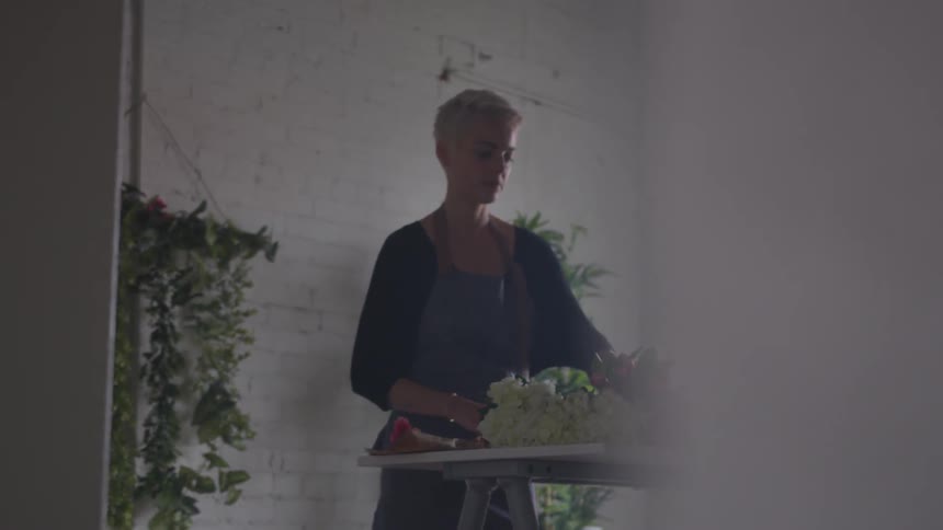 A florist setting up a bouquet at a table