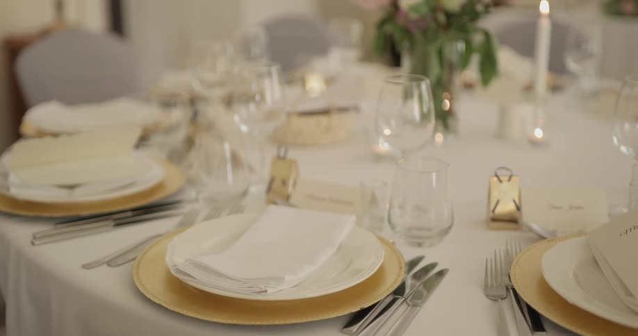 There are plates, napkins, cups,  and utensils on the table