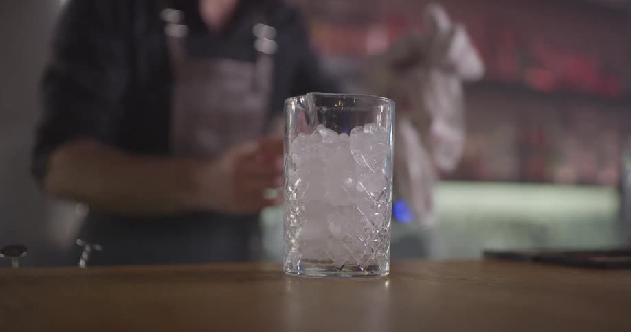 A man wiping off a counter before setting down a glass