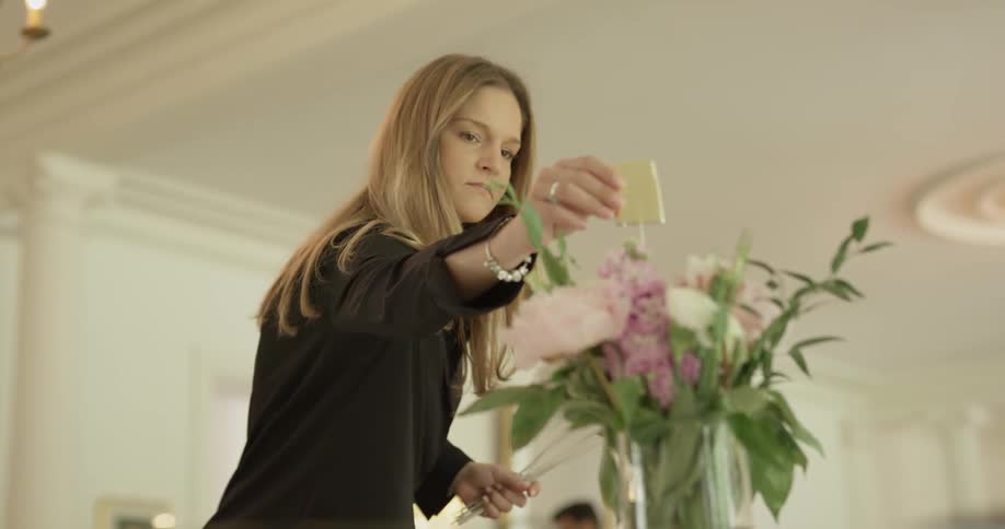 A woman places a note in a vase
