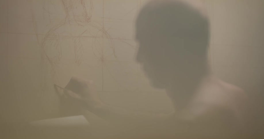 A man draws on a large canvas