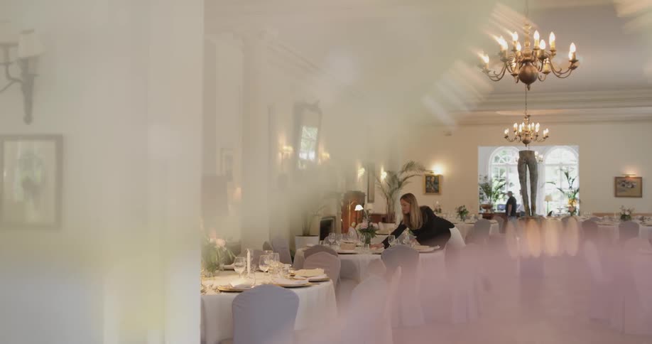 Woman sets a table in a banquet hall