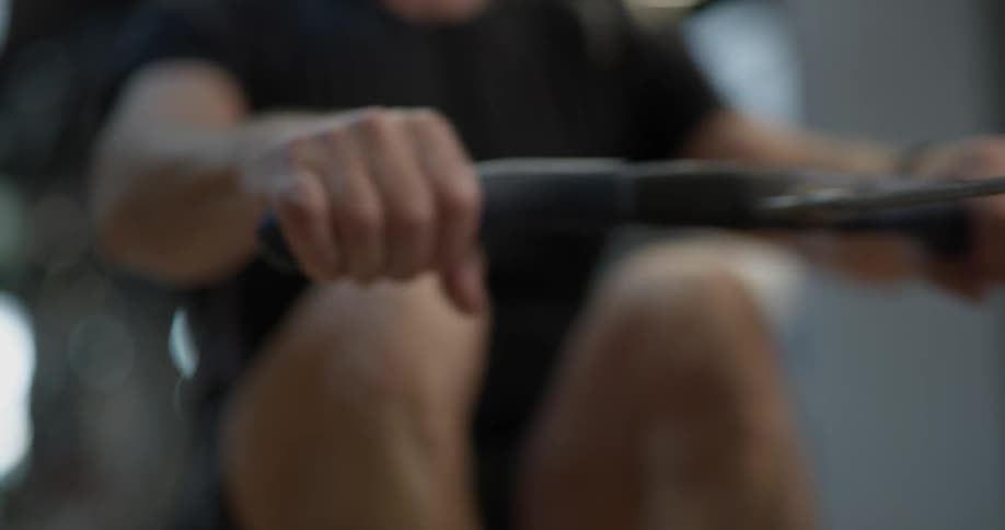 Man is using rowing machine to workout at the gym