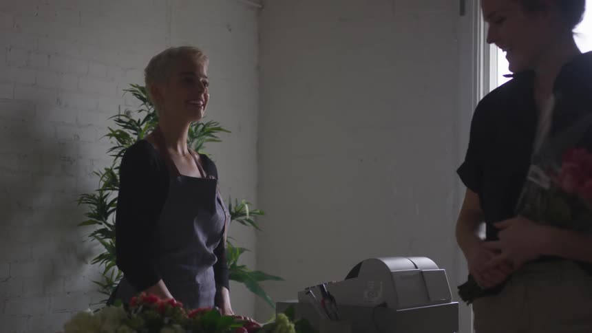 Man buys flowers from female cashier