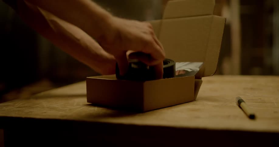 A person is putting items into a box